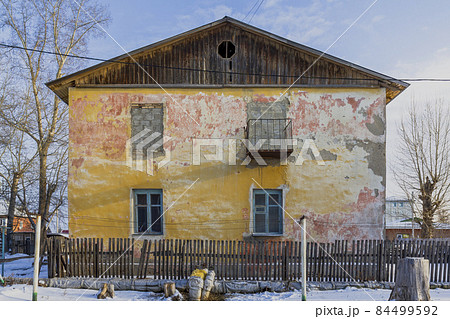An old house with a balcony and a window on the second floor laid in concrete blocks. An old house with a balcony and a window on the second floor laid in concrete blocks. 84499592