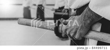 Person practicing aikido in a dojo background. 84499711