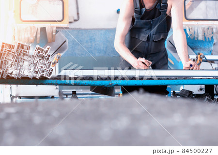 Production of PVC windows, the worker records dimensions on the profile of the frame pvc, felt pen arm Production of PVC windows, the worker records dimensions on the profile of the frame pvc, felt pen arm 84500227