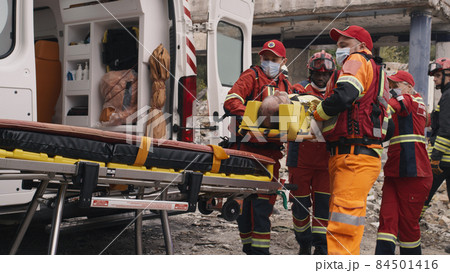Diverse paramedics preparing survivor for transportation Diverse paramedics preparing survivor for transportation 84501416