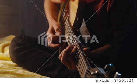 Teen musician playing guitar at night 84501524