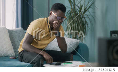 Upset black guy checking bills 84501615