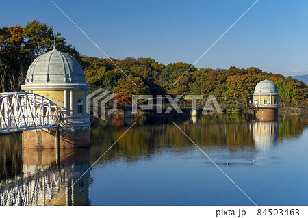 紅葉の多摩湖堤体上から見る湖面と第一取水塔、第二取水塔 84503463