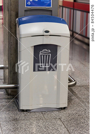 A gray plastic waste basket in a public place A gray plastic waste basket in a public place 84504476