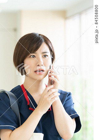 スマホで通話する医療従事者の女性 84508800