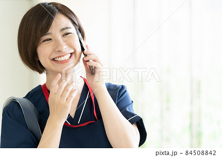 スマホで通話する医療従事者の女性 スマホで通話する医療従事者の女性 84508842