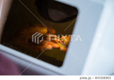 The technician solders the metal frame of the glasses. 84508965