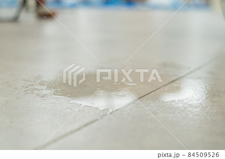 Water drips onto the tiled floor. Water drips onto the tiled floor. 84509526