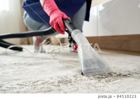 Human Cleaning Carpet In The Living Room Using Vacuum Cleaner At Home Human Cleaning Carpet In The Living Room Using Vacuum Cleaner At Home 84510223