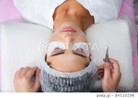 Eyelash Extension Procedure. Woman Eye with Long Eyelashes 84510296