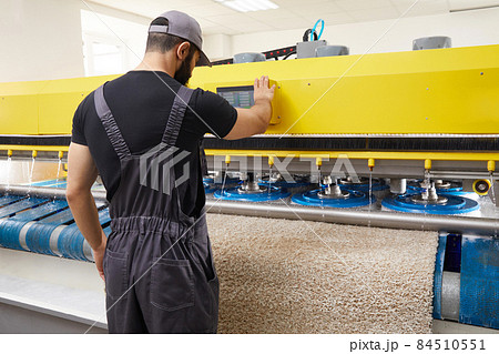 Man operating carpet automatic washing machine in professional laundry service Man operating carpet automatic washing machine in professional laundry service 84510551