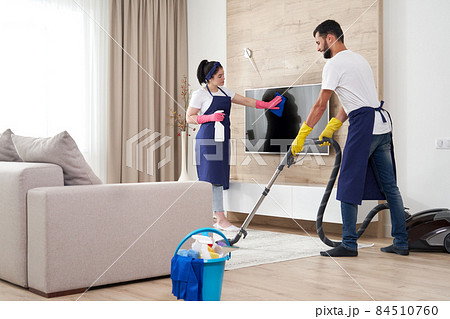 Professional cleaning service team cleans living room in modern apartment Professional cleaning service team cleans living room in modern apartment 84510760