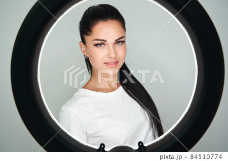 Portrait of young beautiful woman with ring flash. Round LED Circle Lamp in studio Portrait of young beautiful woman with ring flash. Round LED Circle Lamp in studio 84510774
