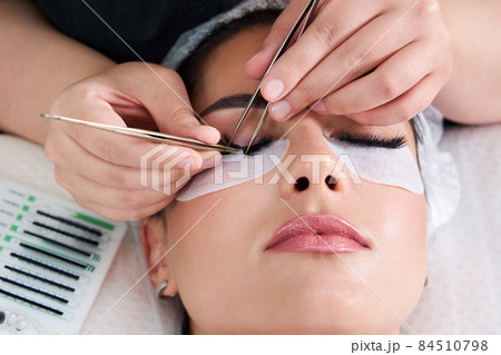 Eyelash Extension Procedure. Woman Eye with Long Eyelashes 84510798
