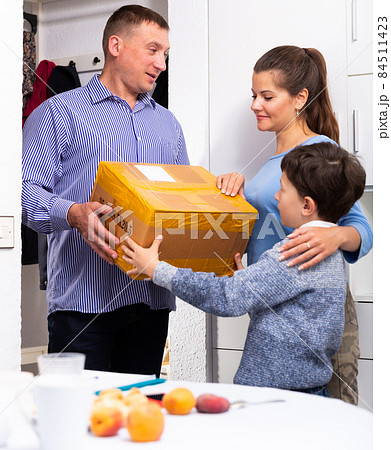 Courier delivering package to woman with son 84511423