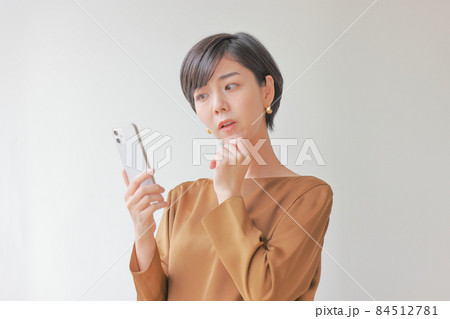 あれれっという顔でスマホを見る女性 あれれっという顔でスマホを見る女性 84512781