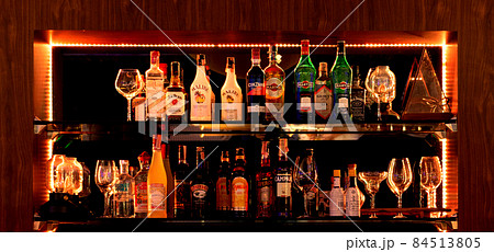 bottles of liqour on shelf in bar at night 84513805