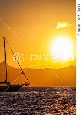 Beautiful sunset on the Aegean Sea with mountains and a sailboat. Seascape, travel and nature concept. High quality photo 84514834