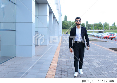 Arabic guy in business center stands smiling walking slow Arabic guy in business center stands smiling walking slow 84517380