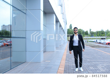 Arabic guy in business center stands smiling walking slow Arabic guy in business center stands smiling walking slow 84517388