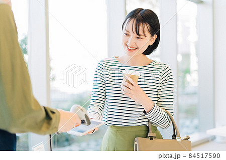 スマホ決済をする若い女性 スマホ決済をする若い女性 84517590