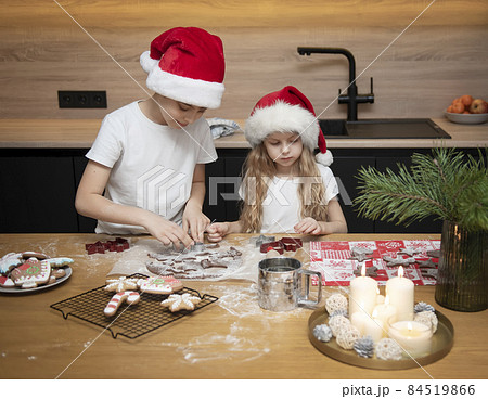 Children - a boy and a girl are preparing gingerbread in the kitchen 84519866