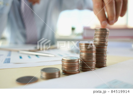 A man in the office puts coins in a row, close-up A man in the office puts coins in a row, close-up 84519914
