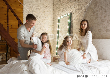 morning family: the children with parents playing in bed. waking up from a dream. I just woke up. love 84520661