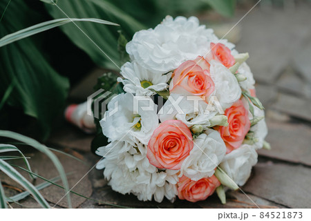 The wedding bouquet of the bride lies on the stone floor. culture, wedding ethical traditions concept. The wedding bouquet of the bride lies on the stone floor. culture, wedding ethical traditions concept. 84521873