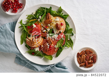 Fruits citrus salad with nuts, green lettuce leaves. Spinach with orange, grapefruit, apples, pecan 84522072