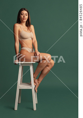 Portrait of young beautiful slim woman in nude color underwear