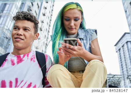 Guy and girl with mobile phone resting in city 84528147