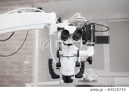 Dental microscope with video camera. against the background of modern dentistry. Medical equipment. operating microscope. with swivel double binoculars. dental microscope. an office in a white office. 84528745