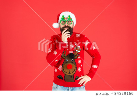 pondering brutal hipster man in santa hat with party glasses on red background, santa pondering brutal hipster man in santa hat with party glasses on red background, santa 84529166