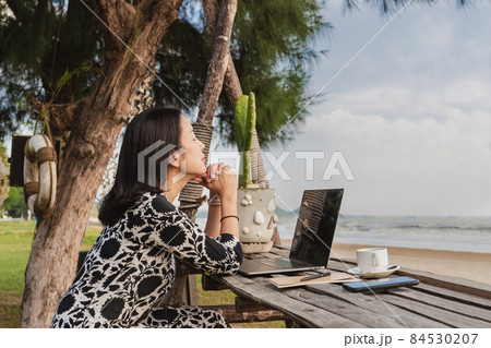 Business woman relaxing breathing fresh air while working with computer on the beach. 84530207