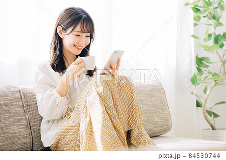 コーヒーを飲みながらスマホを見る女性 コーヒーを飲みながらスマホを見る女性 84530744