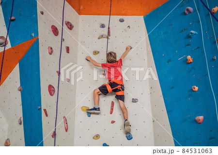 Boy at the climbing wall without a helmet, danger at the climbing wall 84531063