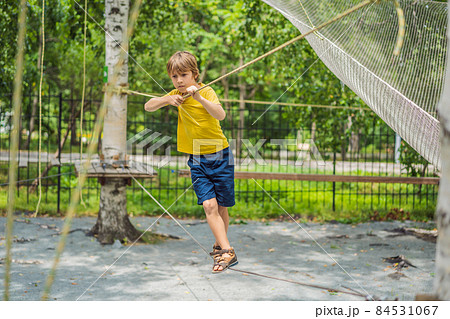 Little boy in a rope park. Active physical recreation of the child in the fresh air in the park. Training for children 84531067