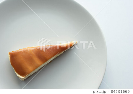 A slice of cheese cake with salted caramel on top A slice of cheese cake with salted caramel on top 84531669