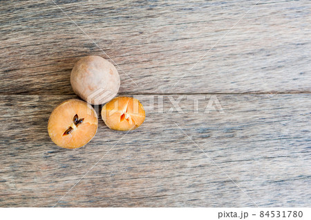 fresh sapodilla fruits on old wooden background fresh sapodilla fruits on old wooden background 84531780