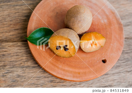 fresh sapodilla fruits on old wooden background fresh sapodilla fruits on old wooden background 84531849