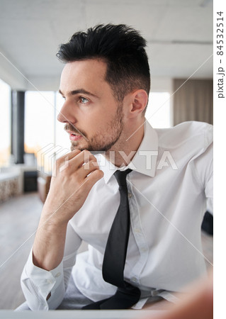 Businessman wearing white shirt and tie looking away and thinking while chatting Businessman wearing white shirt and tie looking away and thinking while chatting 84532514