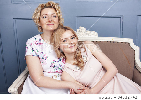 lifestyle people concept: mature blond mother with teenage daughter at home together lifestyle people concept: mature blond mother with teenage daughter at home together 84532742