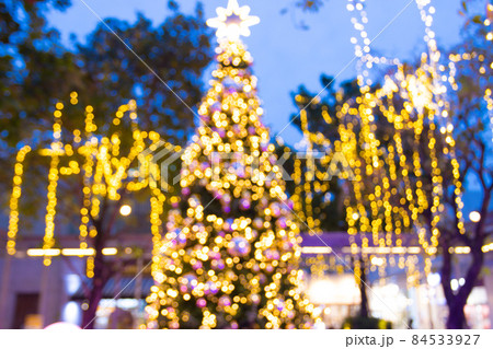 blurred image Decorative outdoor string lights hanging on tree in the garden at night time festivals season - decorative Christmas lights - happy new year 84533927