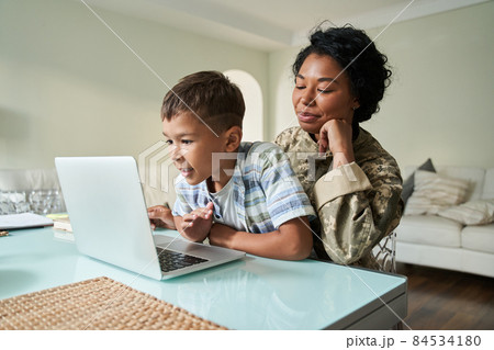Black mother and son watching something on laptop 84534180