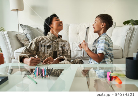 Black boy shows picture in notebook to his mother 84534201
