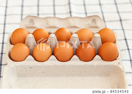 A few brown eggs among the cells of a large cardboard bag, a chicken egg as a valuable nutritious product, a tray for carrying and storing fragile eggs. A full package of eggs, an important food item A few brown eggs among the cells of a large cardboard bag, a chicken egg as a valuable nutritious product, a tray for carrying and storing fragile eggs. A full package of eggs, an important food item 84534543