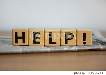 Support and help symbol. Wooden cubes with the word 'help'. Newspaper. Business, psychology, support and help concept. Beautiful wooden table, white background, copy space. Support and help symbol. Wooden cubes with the word 'help'. Newspaper. Business, psychology, support and help concept. Beautiful wooden table, white background, copy space. 84536711