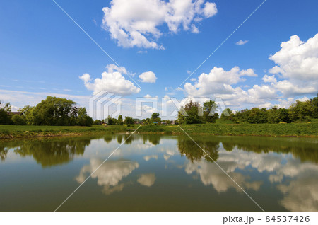 Lake mirror like with dramatic blue sky with clouds Lake mirror like with dramatic blue sky with clouds 84537426