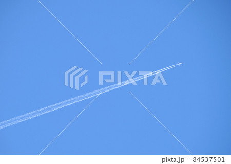 Distant passenger jet plane flying on high altitude on clear blue sky leaving white smoke trace of contrail behind. Air transportation concept. Distant passenger jet plane flying on high altitude on clear blue sky leaving white smoke trace of contrail behind. Air transportation concept. 84537501